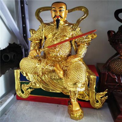 金色鎏金真武大帝銅像，單手持劍一腳盤坐一腳著地的真武祖師塑像